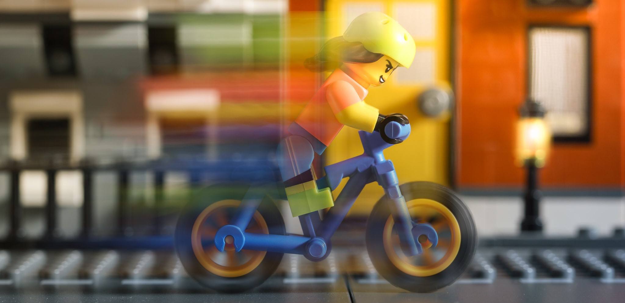 A LEGO going very fast on their mountain bike.