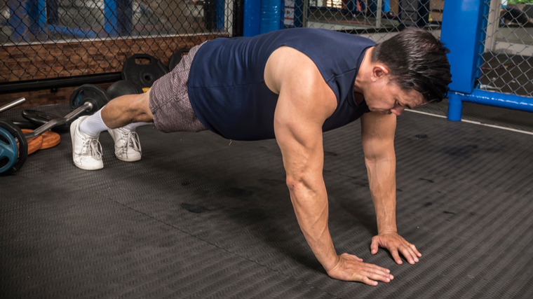 Muscular man performing push-ups on the ground