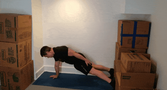 A gif of Coach Jim doing one arm push-ups in a small space.