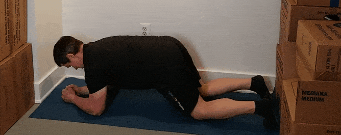 A gif of Coach Jim doing a plank in a small space.