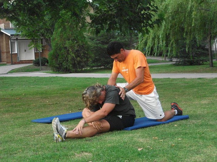 A personal trainer stretching out a client.