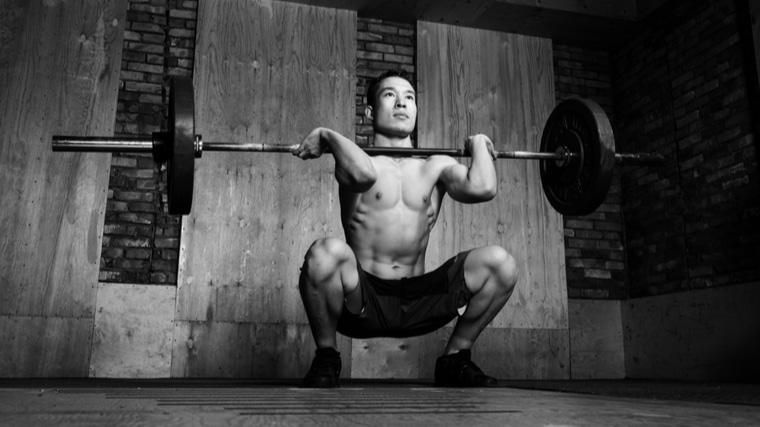 black and white photo of person performing front squat