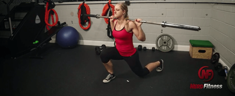 Coach Staci doing a barbell lunge, an advanced lunge variation.