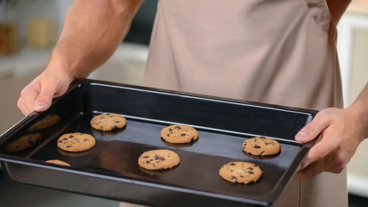 muscular person holding tray of cookies