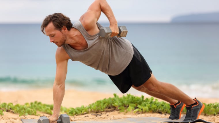 person outdoors performing dumbbell floor exercise