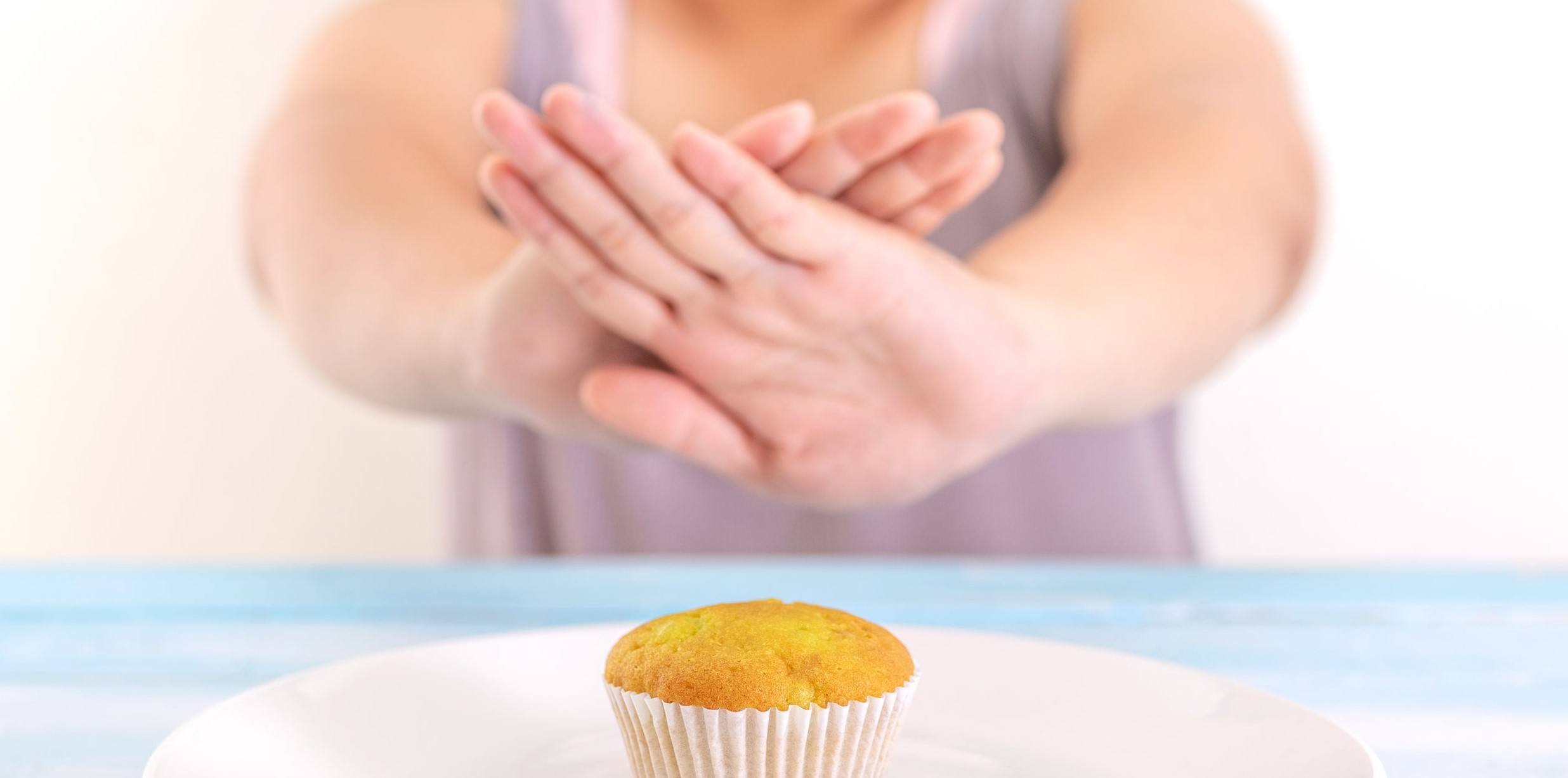 A fasting woman not eating a cupcake