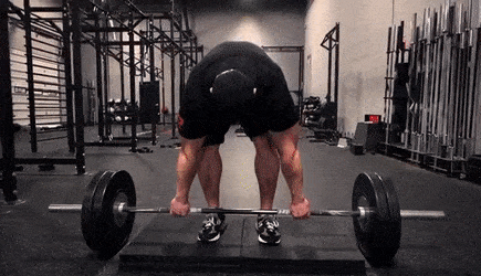 Someone doing a deadlift with a deficit