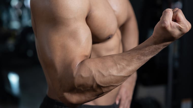 Shirtless bodybuilder flexing biceps muscle