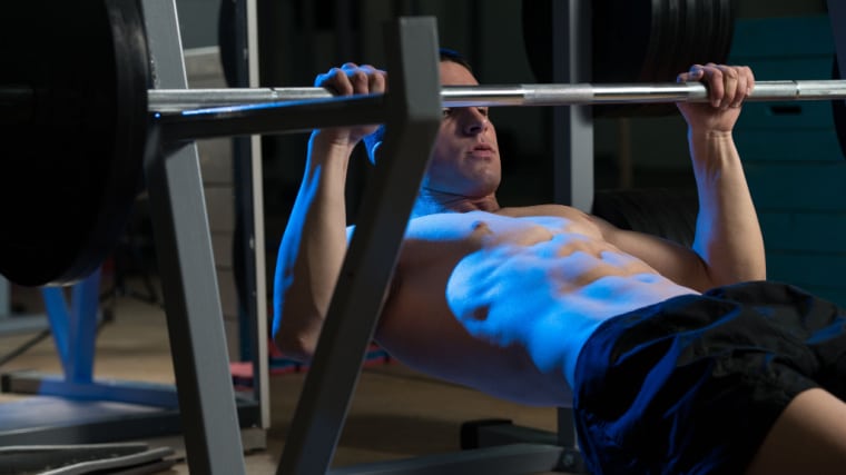 person in dark gym doing back exercise