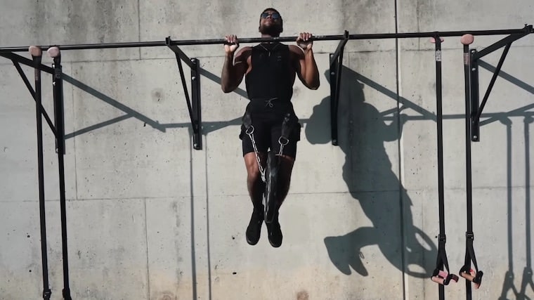 person outdoors performing pull-ups