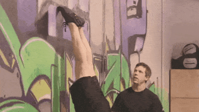 Lifting one leg during a wall walk is how we'll start our full handstand. 
