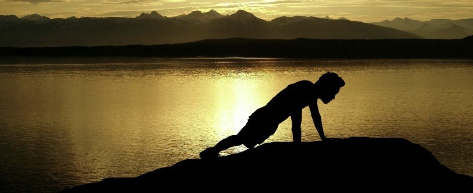 A man doing push-up in sunset